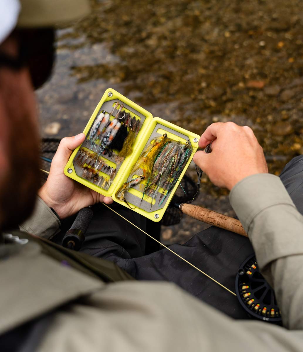 Photo du guide de pêche Maxime en train de sélectionner un streamer